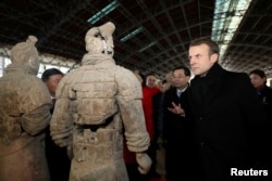 2018年1月8日，法国总统马克龙在中国陕西省西安市参观秦代兵马俑博物馆，近距离观察兵马俑。