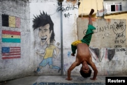 A member of the Acorda Capoeira (Awaken Capoeira) group prepares for a performance for tourists in the Rocinha favela in Rio de Janeiro, Brazil, July 25, 2016.