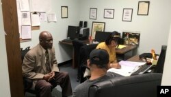 In this May 18, 2017, photo, Nathan Singletary, 67, a social worker for 40 years, listens as Employment Specialist Luz Rivera, 68, interviews program participant Luis Quinones, 66, front right, at the AARP Foundation in Harrisburg, Pa. 