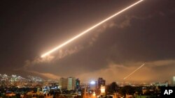 Damascus skies erupt with surface to air missile fire as the U.S. launches an attack on Syria targeting different parts of the Syrian capital Damascus, Syria, early Saturday, April 14, 2018.