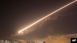 FILE - Damascus skies erupt with surface to air missile fire as the U.S. launches an attack on Syria targeting different parts of the Syrian capital Damascus, Syria, April 14, 2018.