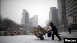 FILE - A man carries scraps in a handcart during snowfall in central Seoul, South Korea, Feb. 16, 2016. With the recycling market dimming, Seoul is turning to upcycling.