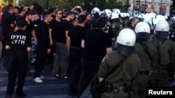 Riot police try to stop members of the Golden Dawn party from unloading food from a vehicle in Athens, Greece, May 2, 2013.