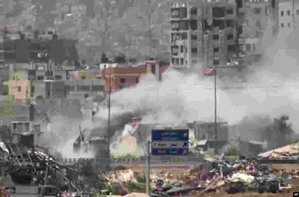 This image taken from video obtained from Ugarit News shows shelling of the Al-Qaboun neighborhood in rural Damascus, Syria, July 15, 2013.
