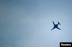 FILE - A U.S.-led coalition aircraft flies over Kobanii, as seen near the Mursitpinar border crossing on the Turkish-Syrian border in the southeastern town of Suruc in Sanliurfa province.