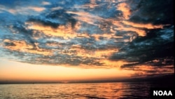 Matahari terbenam terlihat dari pantai Lousiana di Teluk Meksiko dalam gambar yang ditangkap oleh salah satu anggota Korps NOAA.