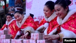 在中国杭州一个公园里，工作人员在一场有奖游戏中摆放的大量百元钞票（2016年1月26日）