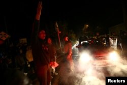 Locals shout slogans as they attempt to block a mountain road during a protest against a new industrial waste processing facility that is being constructed in Til Til, Chile, Aug. 11, 2017.