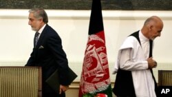 In this Sept. 21, 2014, photo, Afghanistan's then presidential candidates Abdullah Abdullah (L) and Ashraf Ghani leave after signing a power-sharing deal at the presidential palace in Kabul, Afghanistan.