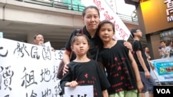 六代都居住在古洞的袁女士帶同一對8歲(前右)及5歲的女兒參加遊行，要求當局撤回新界東北發展計劃 (美國之音湯惠芸拍攝)