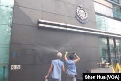2019年6月27日，工人在高壓清洗消除昨晚抗議者噴塗的標語（美國之音申華拍攝）