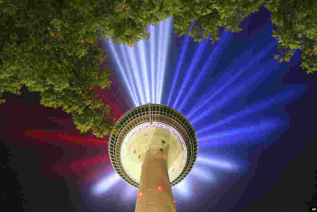 A light installation on the Rhine Tower projects beams in the French national colors during a rehearsal in Duesseldorf, Germany, June 26, 2017