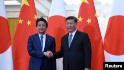 아베 신조 일본 총리와 시진핑 중국 국가주석이 지난 12월 베이징 인민대회당에서 만나 회담에 앞서 악수하고 있다.