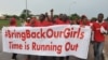 FILE - People shout slogans and hold a banner during a demonstration in Abuja, Nigeria.