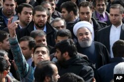 An Iranian man takes a selfie, hoping to capture Iranian President Hassan Rouhani in his picture during a rally marking the 37th anniversary of the Islamic revolution in Tehran on Feb. 11, 2016.