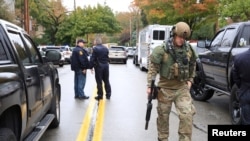 A SWAT police officer and other first responders respond after a gunman opened fire at the Tree of Life synagogue