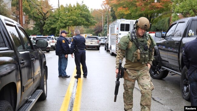 A SWAT police officer and other first responders respond after a gunman opened fire at the Tree of Life synagogue