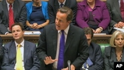 Britain's Prime Minister David Cameron, flanked by Deputy Prime Minister Nick Clegg (L) and Home Secretary Theresa May (R) speaks about phone hacking to parliament in a still image taken from video in London July 20, 2011