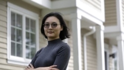 In this Monday, June 15, 2020, photo Xujiao Wang, 32, of East Providence, R.I., stands for a photograph outside her home. Wang works for a Massachusetts company and is on the Optional Practical Training program for student visa holders.