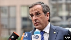 FILE - Greek Prime Minister Antonis Samaras answers journalists' questions as he arrives to attend a European Council meeting at the EU headquarters in Brussels, Oct. 24, 2013 