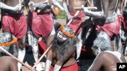 Aboriginal traditional dancers carrying clap sticks and spears and with faces painted white with clay perform in front of Parliament House in Canberra, Australia, Nov. 28, 2016. 