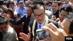 Sam Rainsy memberikan keterangan kepada media setibanya di luar gerbang bandara, sebelum melanjutkan perjalanannya ke Phnom Penh, Kamboja, 16 Agustus 2013. (Foto: VOA/Robert Carmichael)