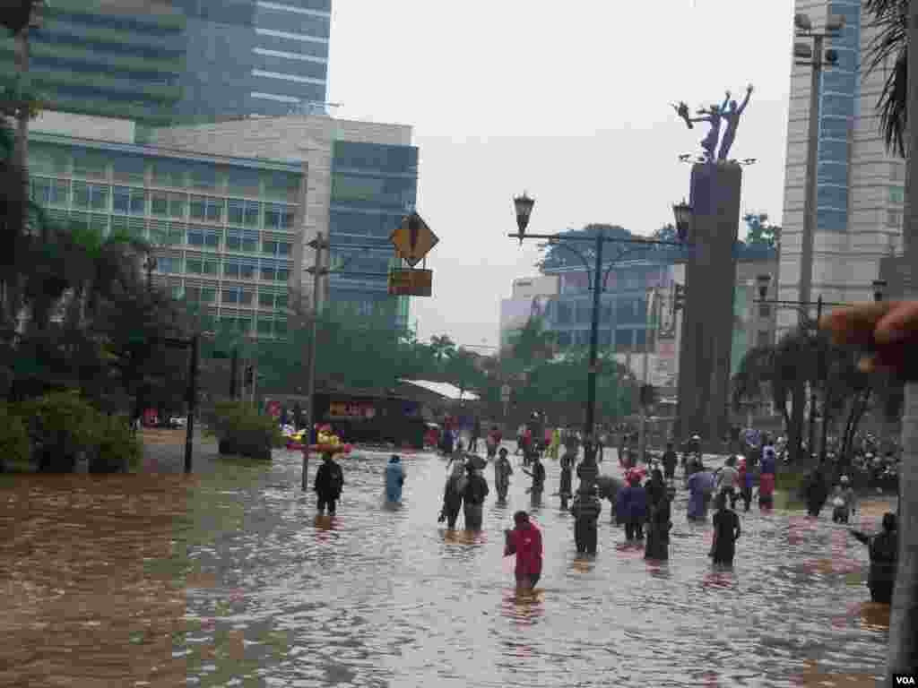 People walk through Jakarta's flooded streets, Indonesia, January 17, 2013. (VOA Indonesian Service)