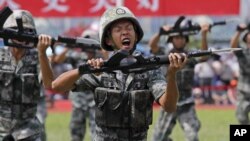 FILE - In this June 30, 2019, file photo, soldiers of Chinese People's Liberation Army (PLA) demonstrate their skill during an open day of Stonecutter Island naval base, in Hong Kong, to mark the 22nd anniversary of Hong Kong handover to China. The Chines