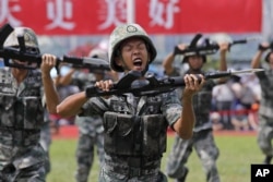 ANggota Tentara Pembebasan Rakyat China (PLA) memperagakan keterampilan mereka di pangkalan angkatan laut Pulau Stonecutter, Hong Kong, pada peringatan 22 tahun penyerahan Hong Kong ke China, 30 JUli 2019. (Foto: dok).