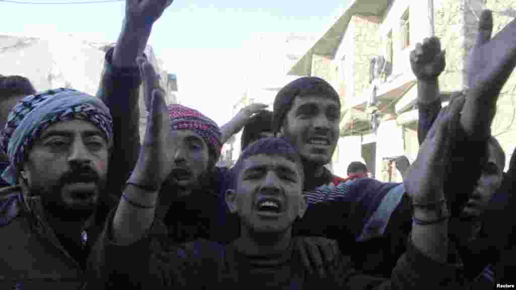 People react after what activists said was an air raid by forces loyal to Syrian President Bashar Al-Assad in the al-Marja district of Aleppo, Dec. 23, 2013.