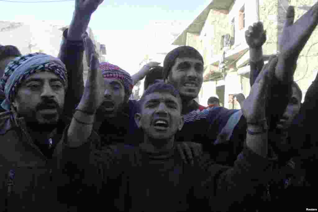 People react after what activists said was an air raid by forces loyal to Syrian President Bashar Al-Assad in the al-Marja district of Aleppo, Dec. 23, 2013.