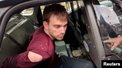 Travis Reinking, the suspect in a Waffle House shooting in Nashville, is under arrest by Metro Nashville Police Department in a wooded area in Antioch, Tennessee, April 23, 2018. 