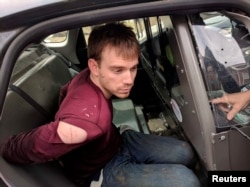 FILE - Travis Reinking, the suspect in a Waffle House shooting in Nashville, is under arrest by Metro Nashville Police Department in a wooded area in Antioch, Tennessee, April 23, 2018.