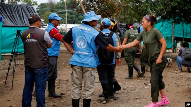 Un observador de Naciones Unidas estrecha la mano de un rebelde de las FARC, antes de un encuentro en La Carmelita, cerca de Puerto Asis, en el suroeste de Putumayo, miércoles 1 de marzo de 2017.