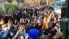 FILE - University students attend a protest inside Tehran University while anti-riot Iranian police prevent them from joining other protesters, in Tehran, Iran.