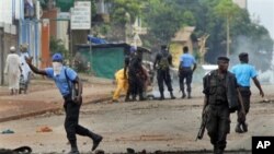 Guinean police carrying automatic weapons clear the mostly Peul suburb of Bambeto in Conakry, Guinea, 16 Nov.2010, as groups of UFDG youth set up barricades. A de-facto curfew is in effect in the area, residents staying inside, one day after it was announ