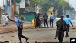 Guinean police carrying automatic weapons clear the mostly Peul suburb of Bambeto in Conakry, Guinea, 16 Nov.2010, as groups of UFDG youth set up barricades. A de-facto curfew is in effect in the area, residents staying inside, one day after it was announ