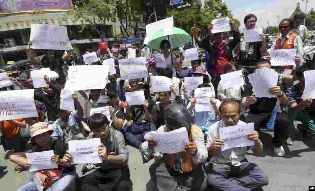 Estudantes tailandeses e activistas seguram cartazes anti-golpe durante um pequeno protesto junto ao Monumento da Democracia em Banguecoque, Maio 23, 2014.