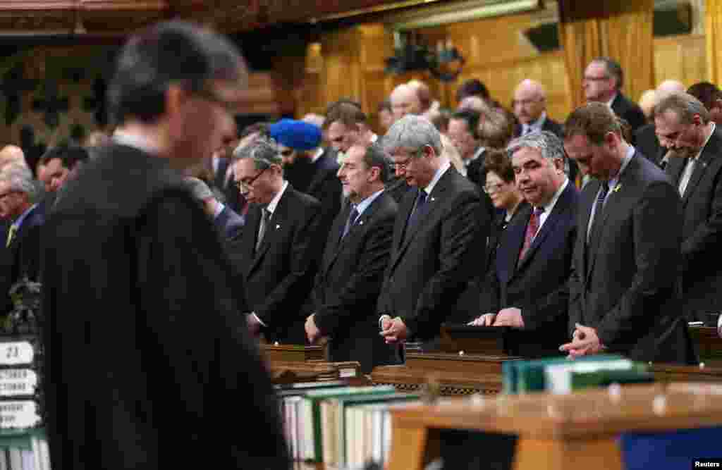 Members of Parliament have a moment of silence in the House of Commons in Ottawa, Oct. 23, 2014.
