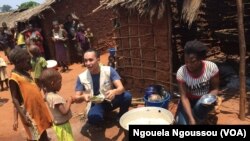 Aloys Robin du PAM avec les enfants ORA pendant la cantine scolaire à Makodi dans le nord du Congo-Brazzaville, 23 mars 2017. (VOA/ Ngouela Ngoussou)