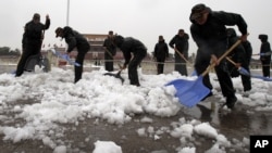 Chinese paramilitary police shovel snow accumulated on Tiananmen Square in Beijing, November 4, 2012.