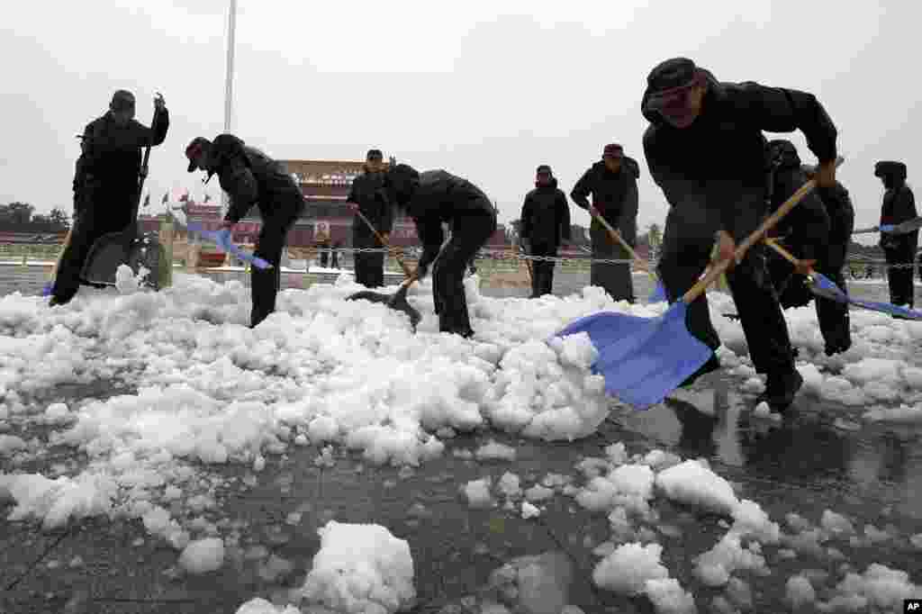 Chinese paramilitary police shovel snow accumulated on Tiananmen Square in Beijing, November 4, 2012.