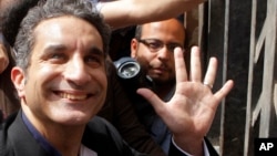 Bassem Youssef waves to his supporters as he enters Egypt's state prosecutors office in Cairo, Mar. 31, 2013.