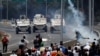 Opposition demonstrators face military vehicles near the Generalisimo Francisco de Miranda Airbase "La Carlota" in Caracas, Venezuela, April 30, 2019. 