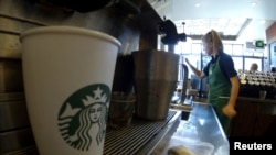 FILE - A barista makes drinks inside a Starbucks coffee shop in Fountain Valley, California, Aug. 22, 2013. 