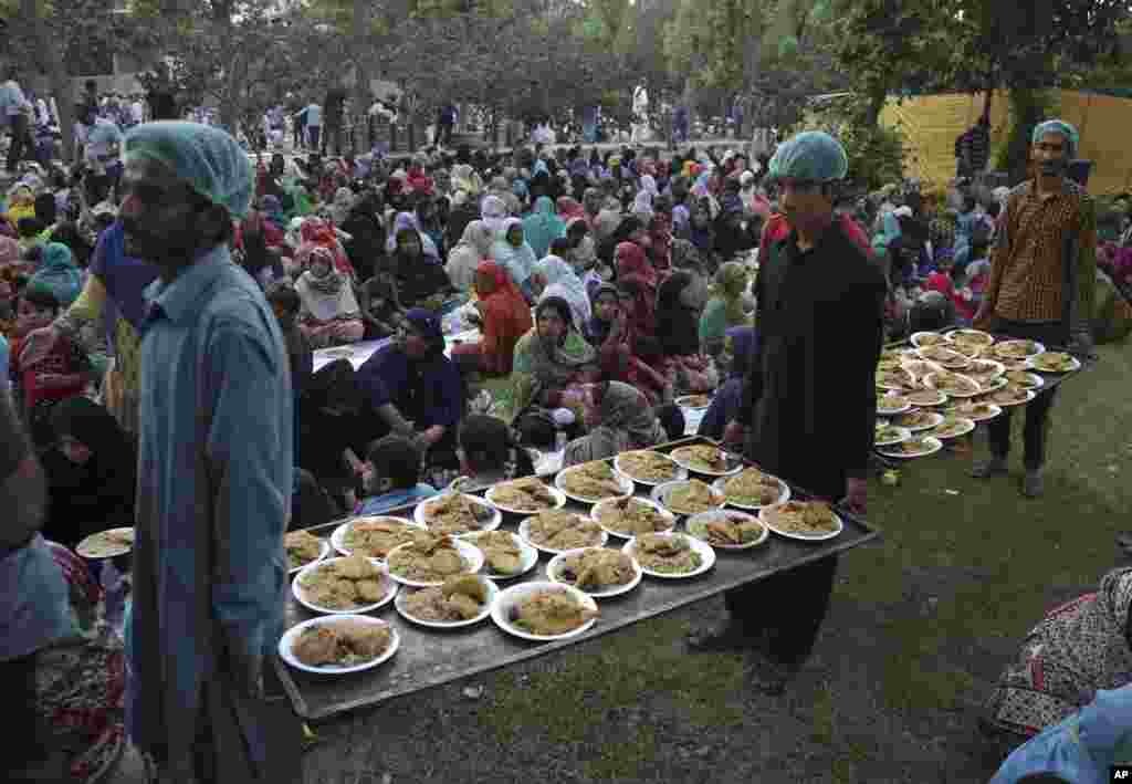 Volunteers distribute food to Muslims for breaking their Ramadan fast at a free food distribution point in Lahore, Pakistan.