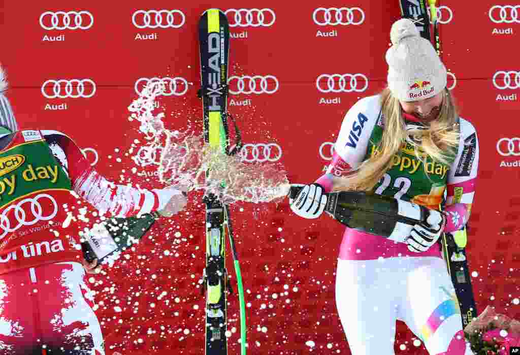 Lindsey Vonn, right, and second placed Anna Fenninger spray sparkling wine on the podium after Vonn clinched an alpine ski, women&#39;s World Cup super-G, in Cortina d&#39;Ampezzo, Italy.