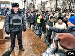 A protester in Moscow's Pushkin Square makes a peace offering to police. Independent monitoring groups put arrests at 340 nationwide. (Photo: Charles Maynes for VOA)