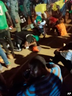 People assist victims of a stampede outside a stadium hosting an African Cup of Nations soccer game in Yaounde, Cameroon, Jan. 24, 2022.
