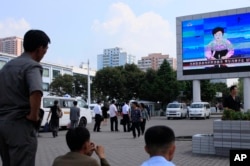 North Koreans watch a news report regarding a nuclear test on a large screen outside the Pyongyang Station in Pyongyang, North Korea, Friday, Sept. 9, 2016.